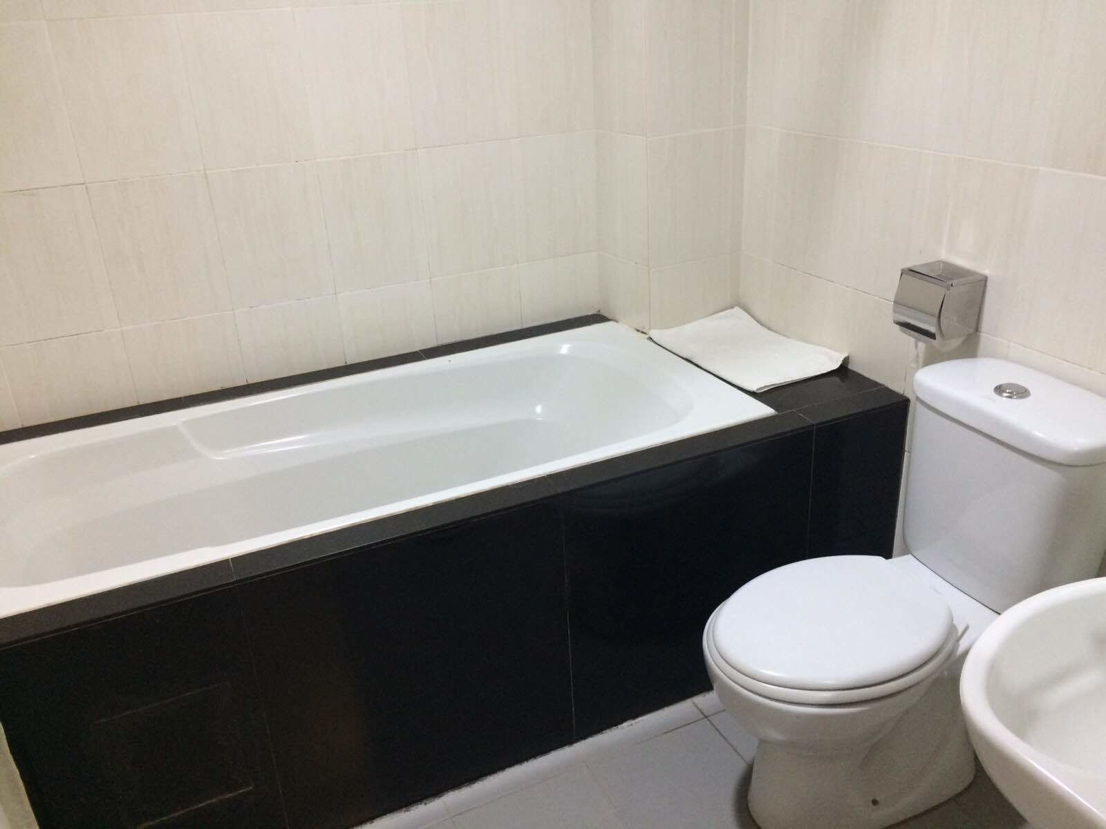 A modern bathroom with a bathtub, toilet, and bidet.