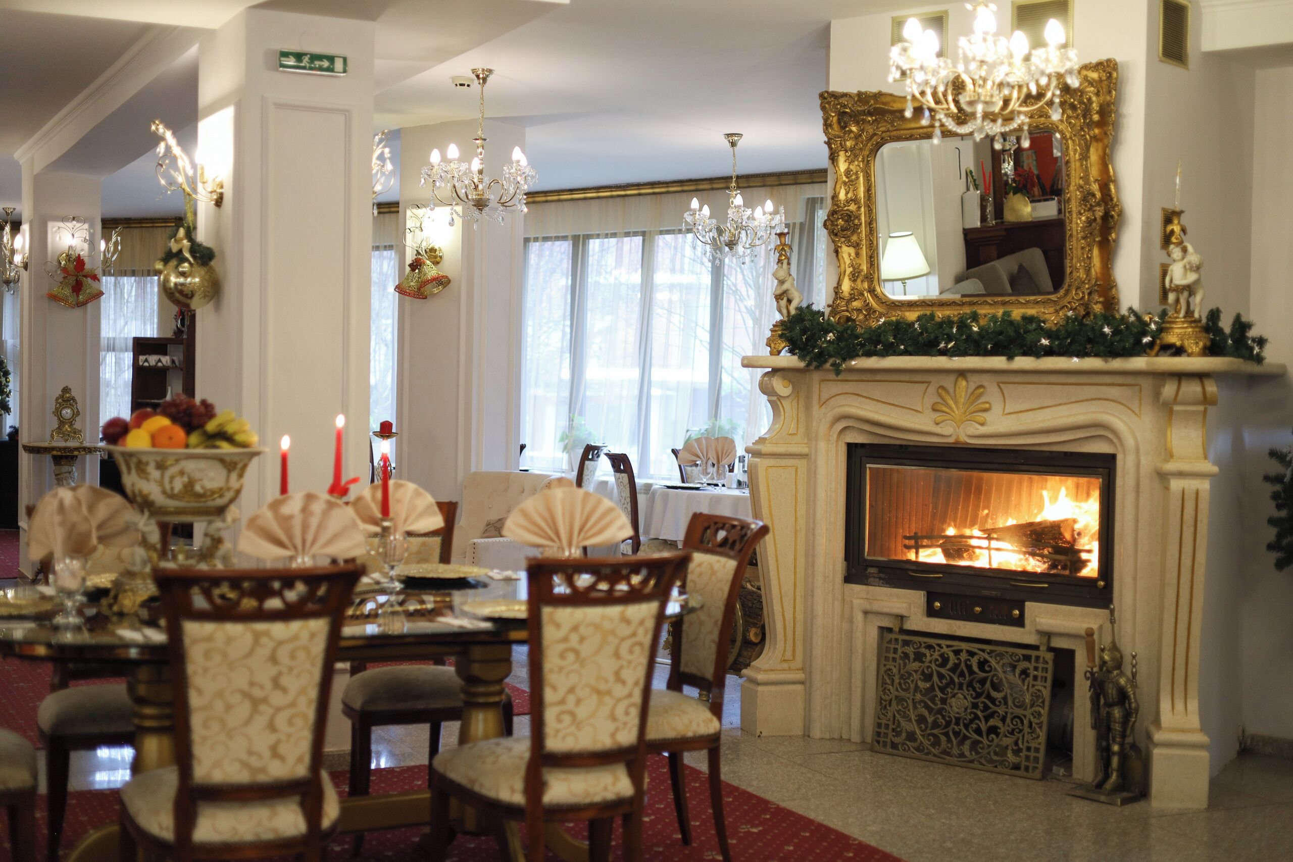 Comedor con chimenea, candelabros y un espejo grande.