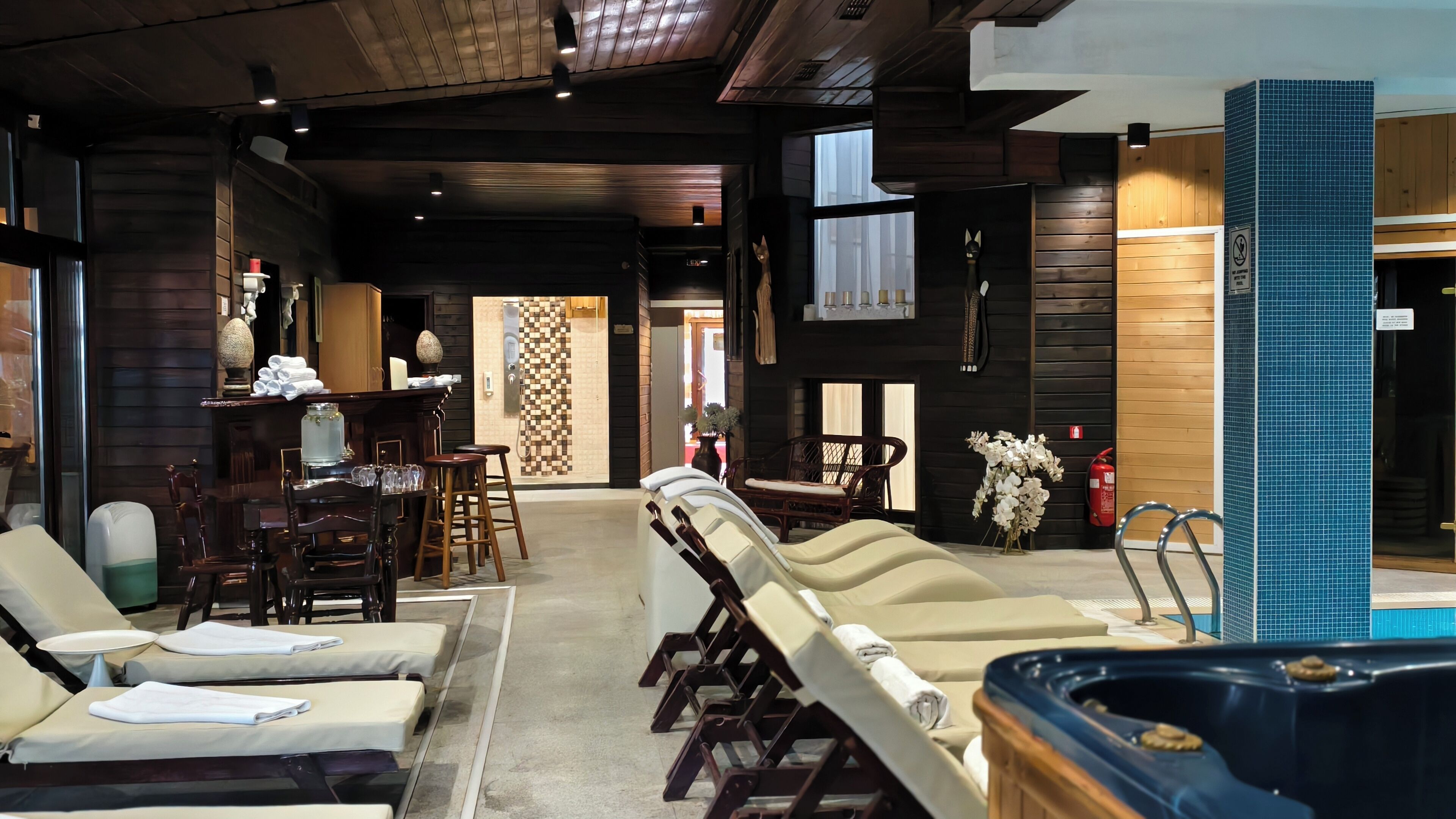 A spa area with multiple sun loungers, a hot tub, and a reception desk.
