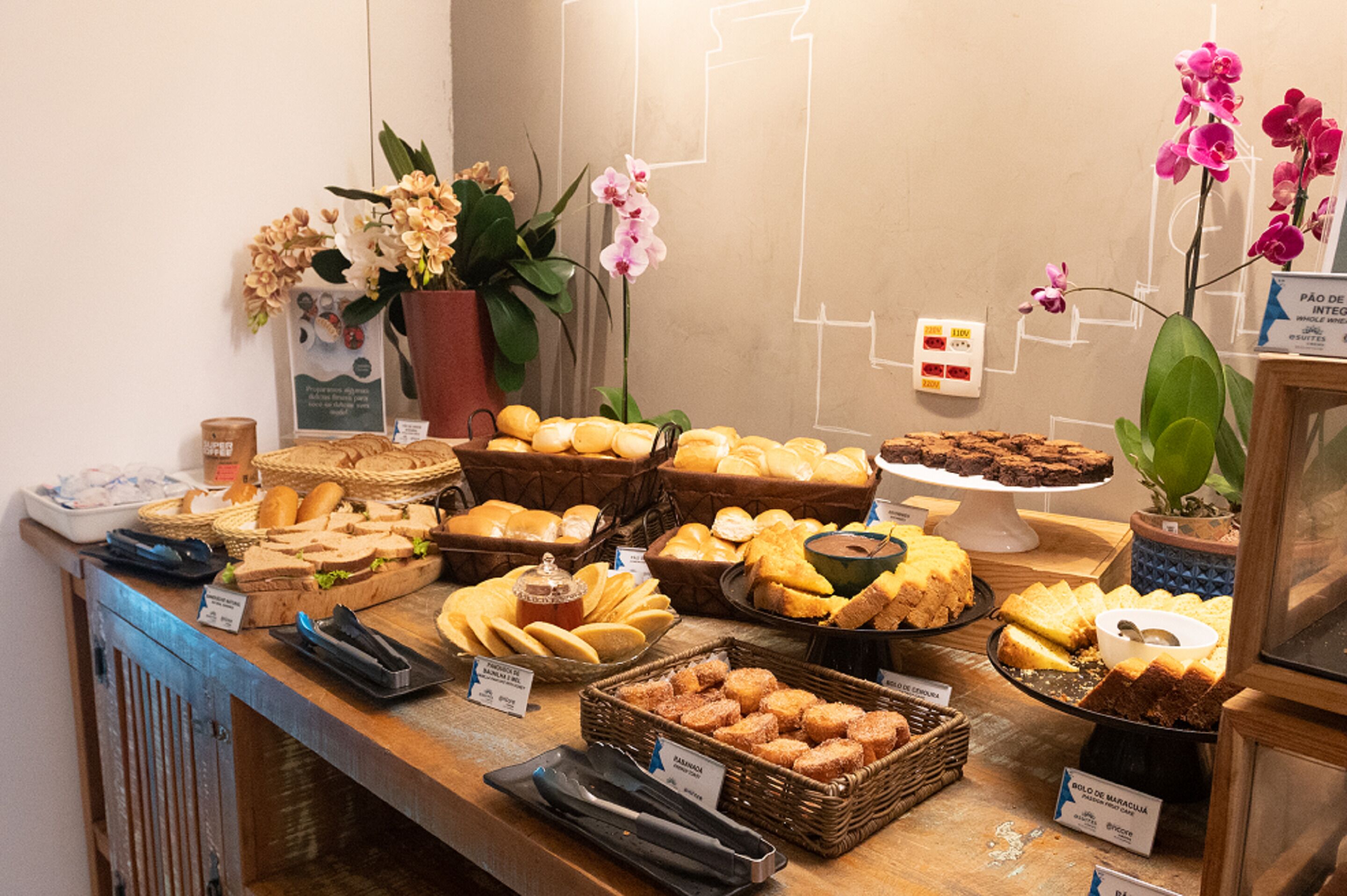 A buffet with various breads, pastries, and desserts.