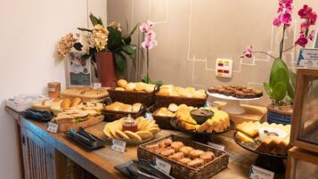 A buffet with various breads, pastries, and desserts.