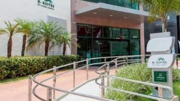 Un bâtiment moderne avec une enseigne indiquant « e. SUITES » et une rampe d’accès pour les personnes à mobilité réduite menant à l’entrée.