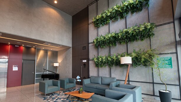 A lobby with a piano, sofas, a coffee table, and a potted plant. - Esuites Virginia Luxemburgo BH (Belo Horizonte)