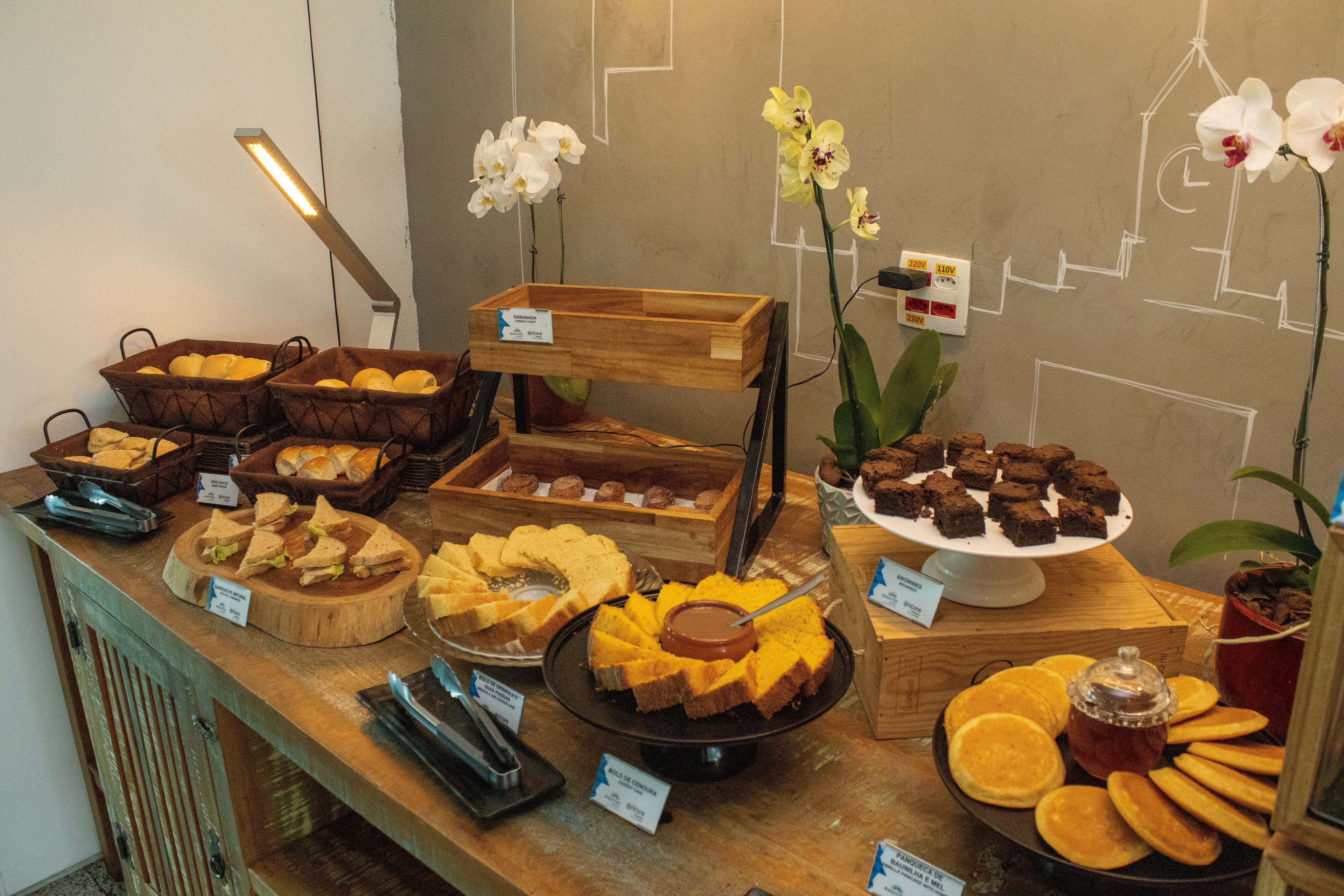 Un bufé con diferentes opciones de comida, como sándwiches, pasteles y productos de pastelería.