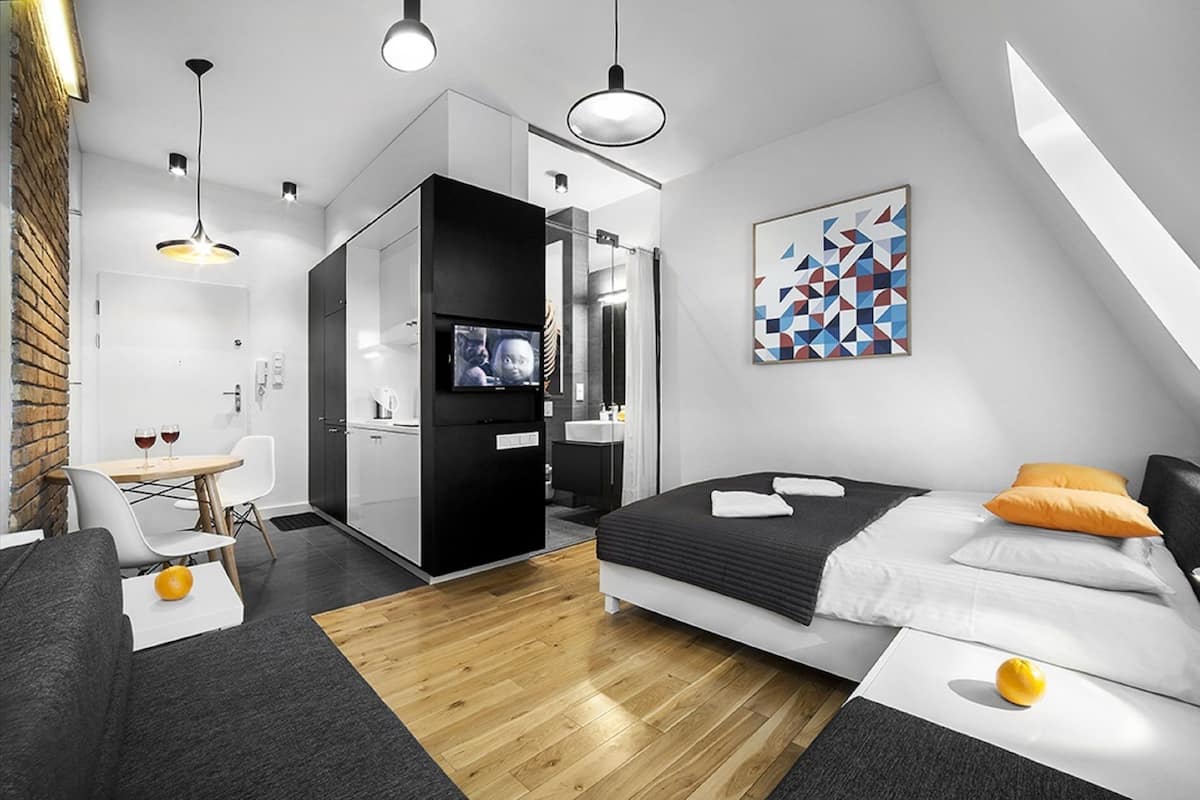 Une chambre d’hôtel moderne équipée d’un lit, d’un bureau, d’une chaise, d’une télévision et d’une salle de bain.
