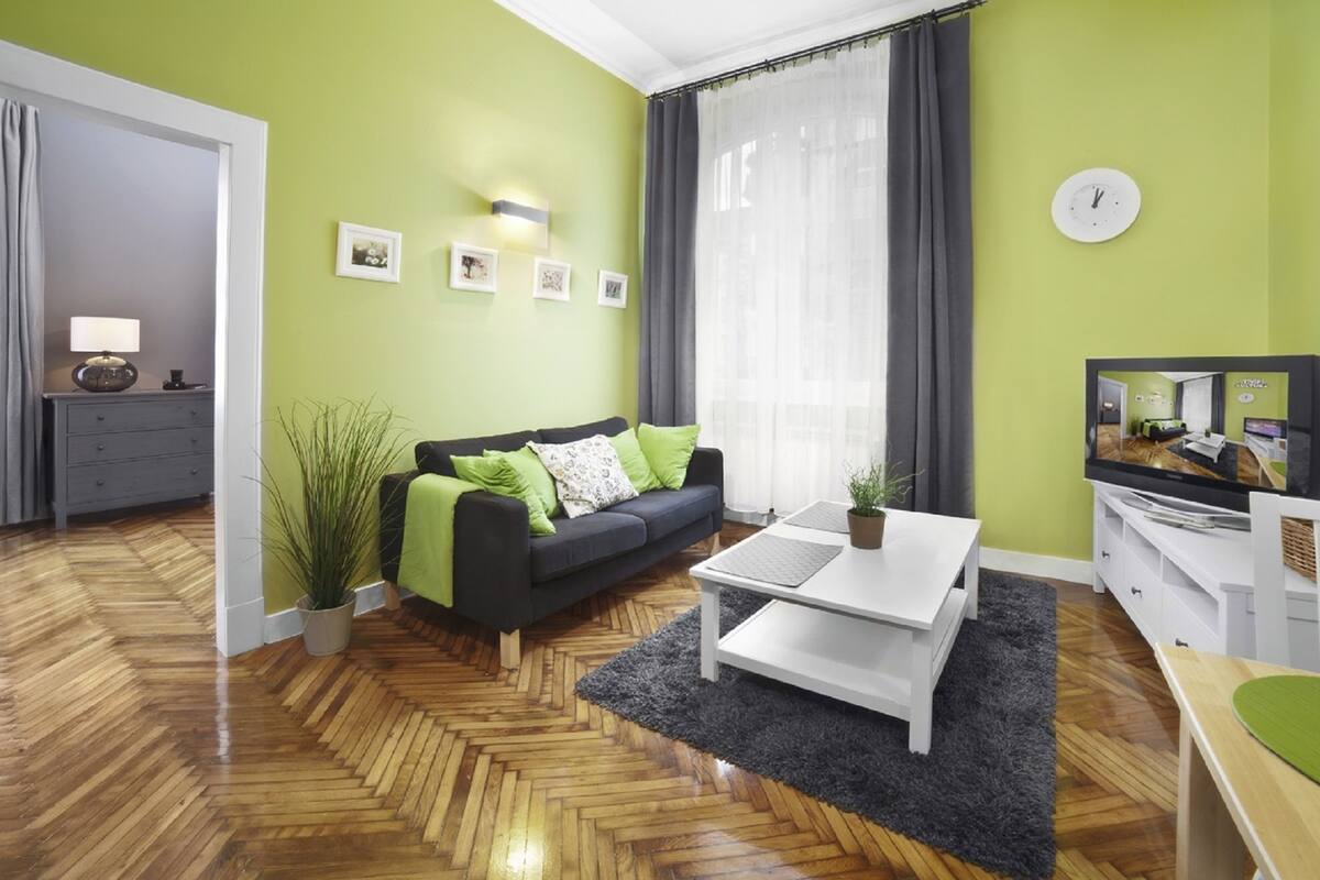 Un salon moderne avec un canapé, une table basse et un téléviseur.
