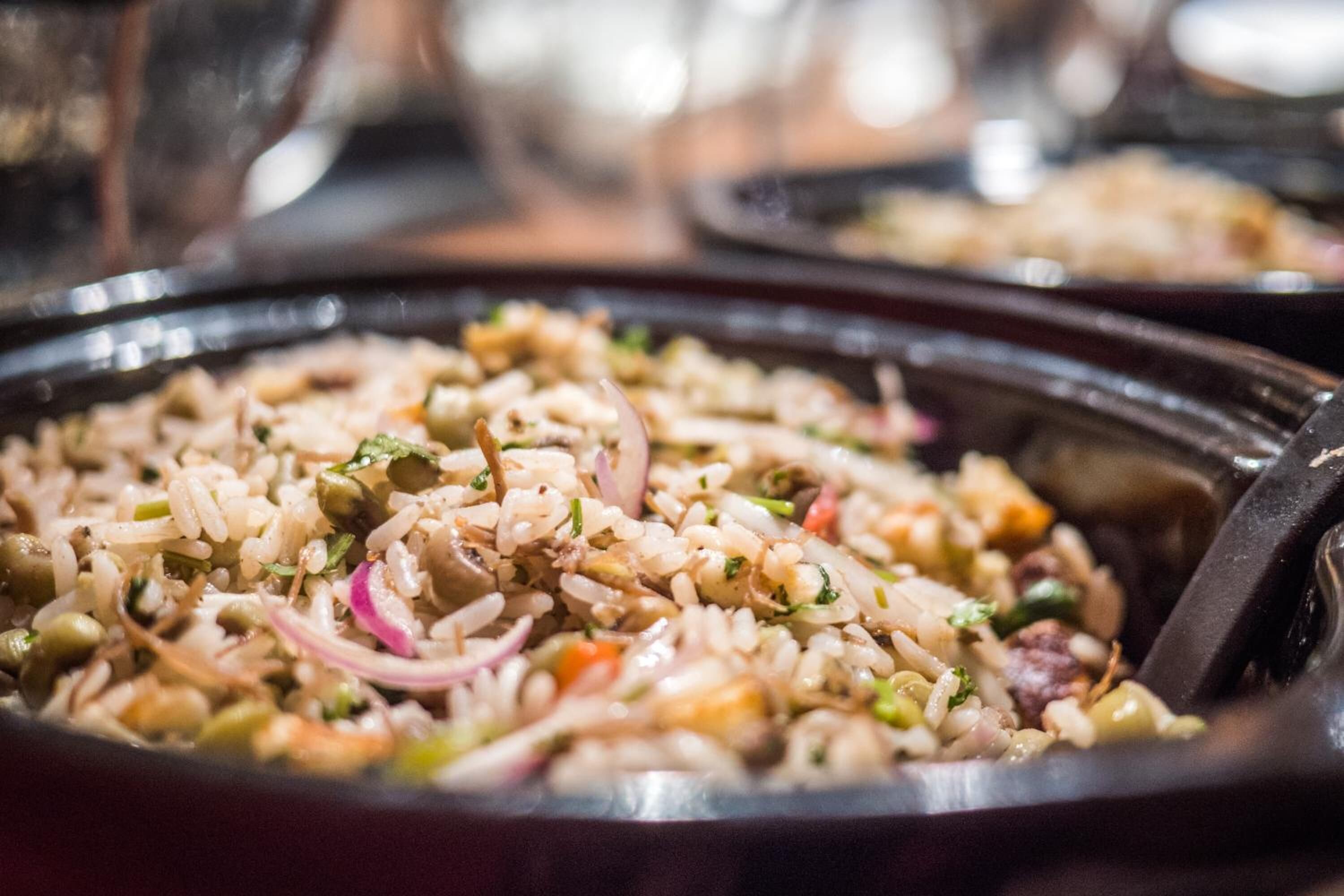A close-up of a dish with rice, vegetables, and possibly meat.