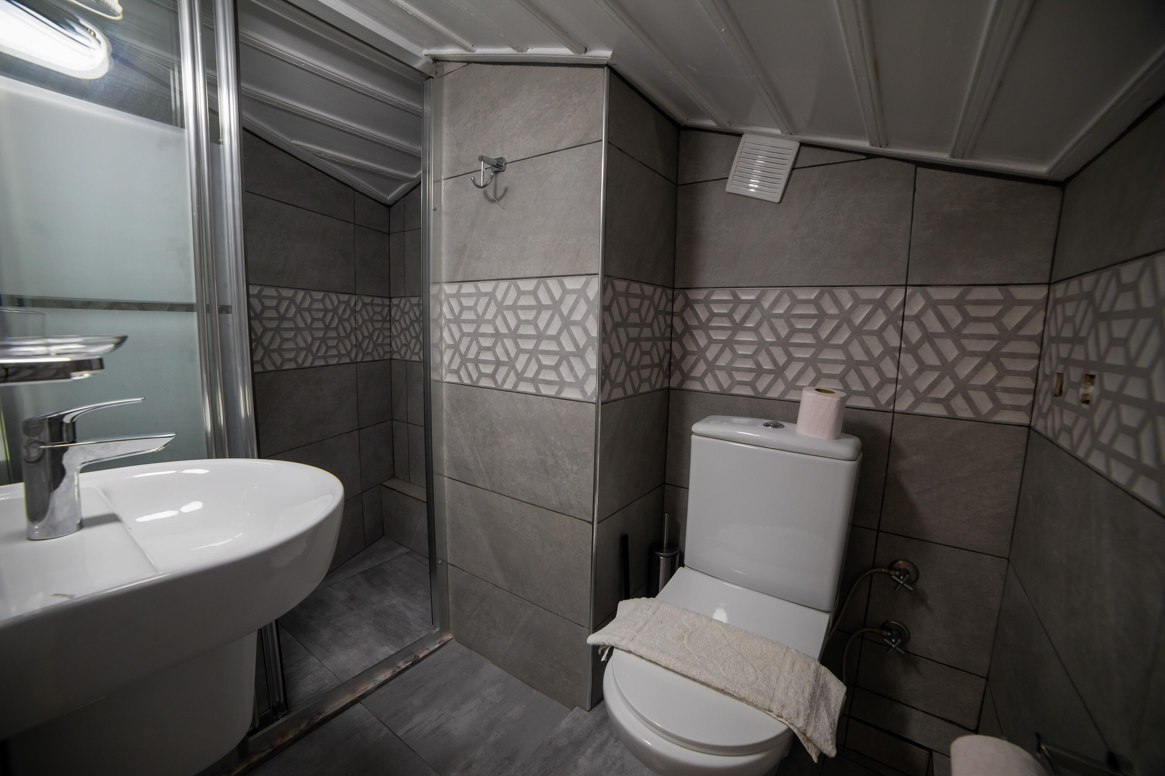 A bathroom with a sink, toilet, and shower.