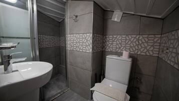 A bathroom with a sink, toilet, and shower.