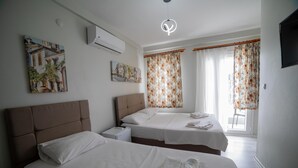 Habitación de hotel con dos camas, cabecera, televisión de pantalla plana y obras de arte en las paredes.