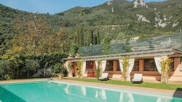 Piscine extérieure, parasols de plage, chaises longues