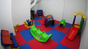 Kids can play on the interlocking foam mats and enjoy the green slide, blue climbing structure, and red slide.