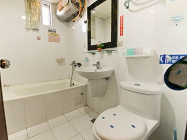 A small, compact bathroom with a bathtub, a sink, and a toilet. - Anping Egret Bay B&B (Tainan)