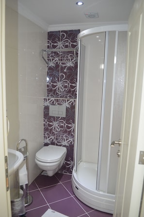 A bathroom with a shower, toilet, and sink.