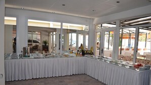Un buffet disposé sur une table recouverte d’une nappe blanche, avec de la vaisselle et différents plats.