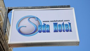 Une enseigne pour l’hôtel SEDA, avec l’adresse de son site web.