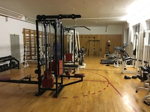 A gym with various exercise equipment, including a squat rack, dumbbells, and a bench. - Hotel Reykjanes (Reykjanes)