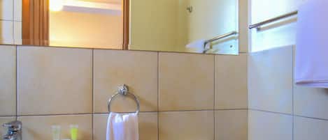 A bathroom with a sink, toilet, and mirror.