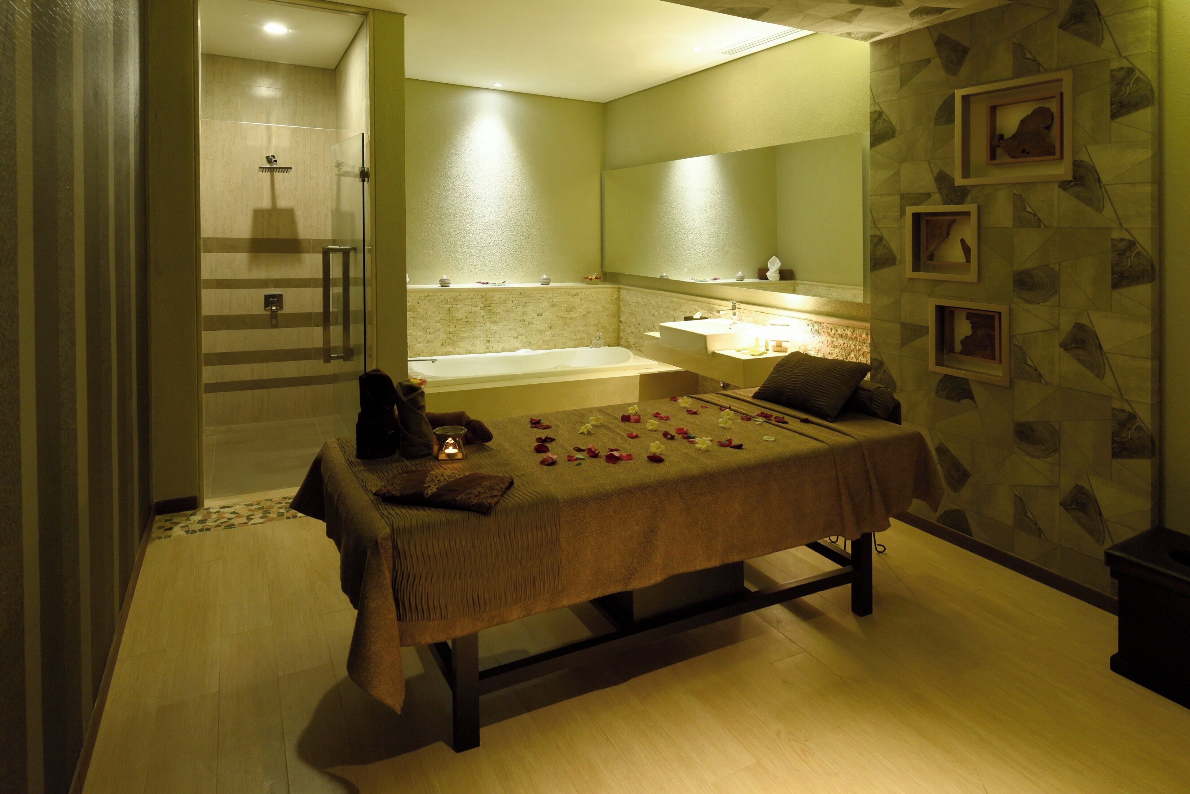 Una habitación con cama, bañera, ducha y espejo.