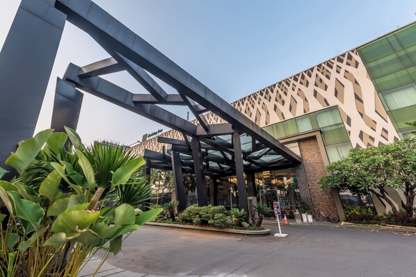 Un edificio moderno con fachada geométrica y un área de acceso cubierta.