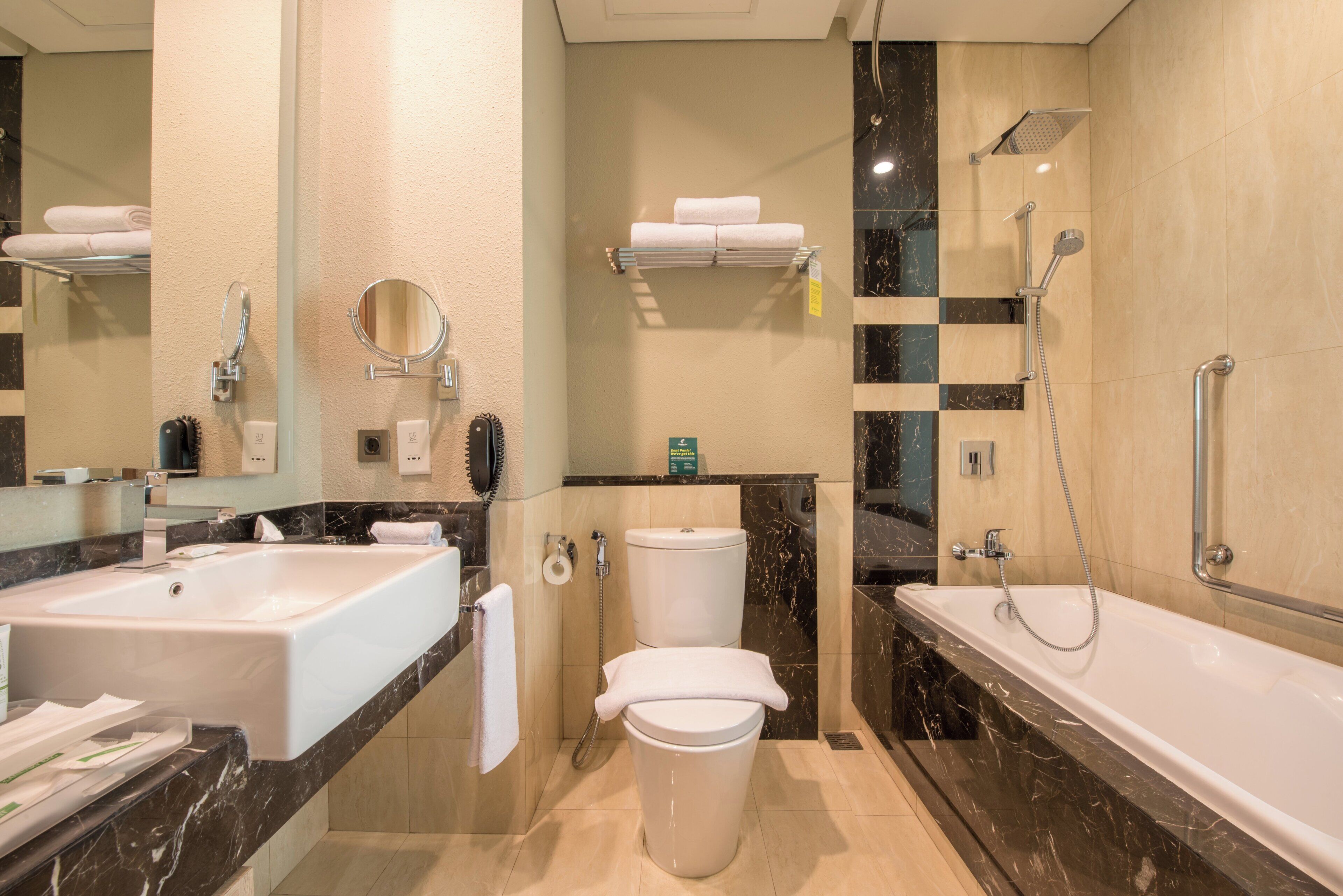 A modern bathroom with a large sink, a toilet, and a bathtub.