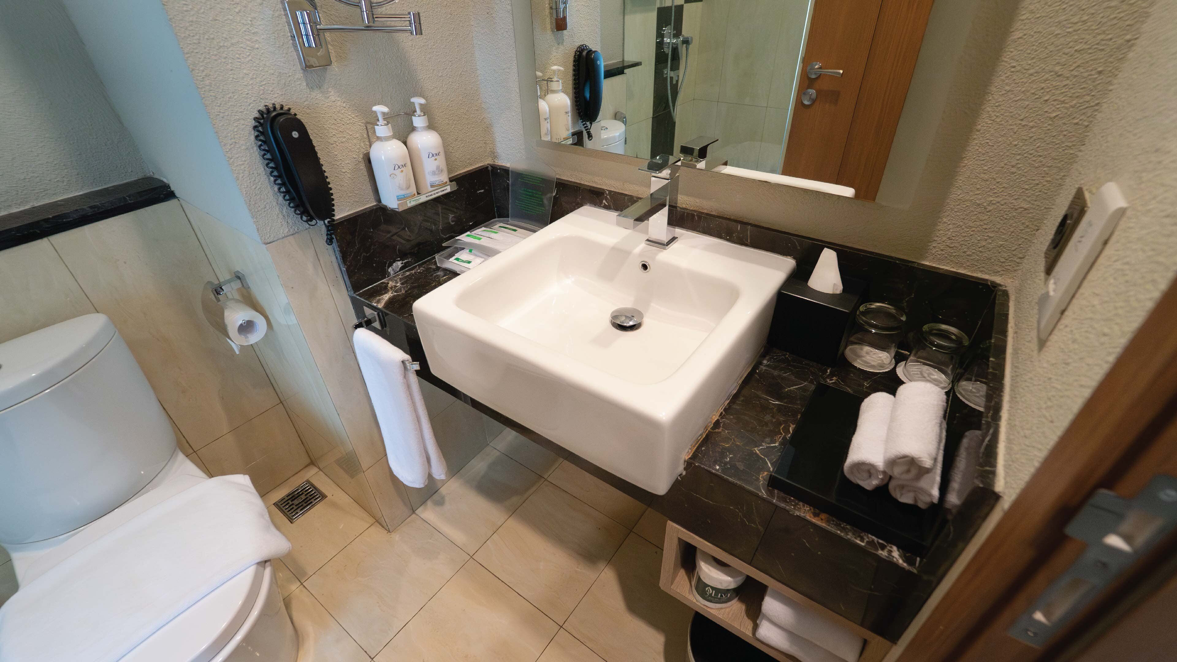 A bathroom with a toilet, sink, and shower.
