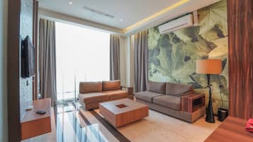 Una sala moderna con un conjunto de sofás, una mesa de centro y un televisor.