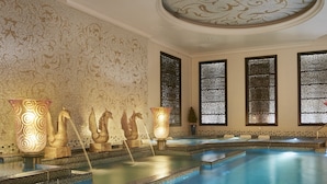 A luxurious indoor swimming pool with ornate wall decorations and a decorative fountain. - Crowne Plaza Kuwait Al Thuraya City by IHG (Farwaniya)