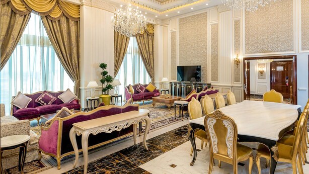 A luxurious living room with a sofa set, a dining table, and a chandelier. - Crowne Plaza Kuwait Al Thuraya City by IHG (Farwaniya)