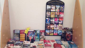 Una exhibición de libros de viaje con un letrero que dice "VISITES PASSION Servez-vous" y varias guías de viaje y folletos.