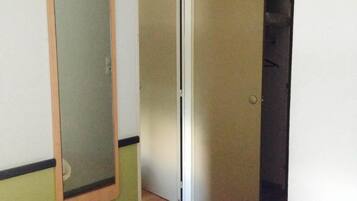 A hotel room with a bed, a mirror, and a door leading to a closet.