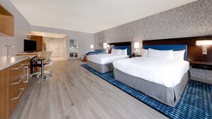 A hotel room with two beds, a desk with a chair, and a kitchenette. - Home2 Suites by Hilton Orlando/International Drive South (Orlando)