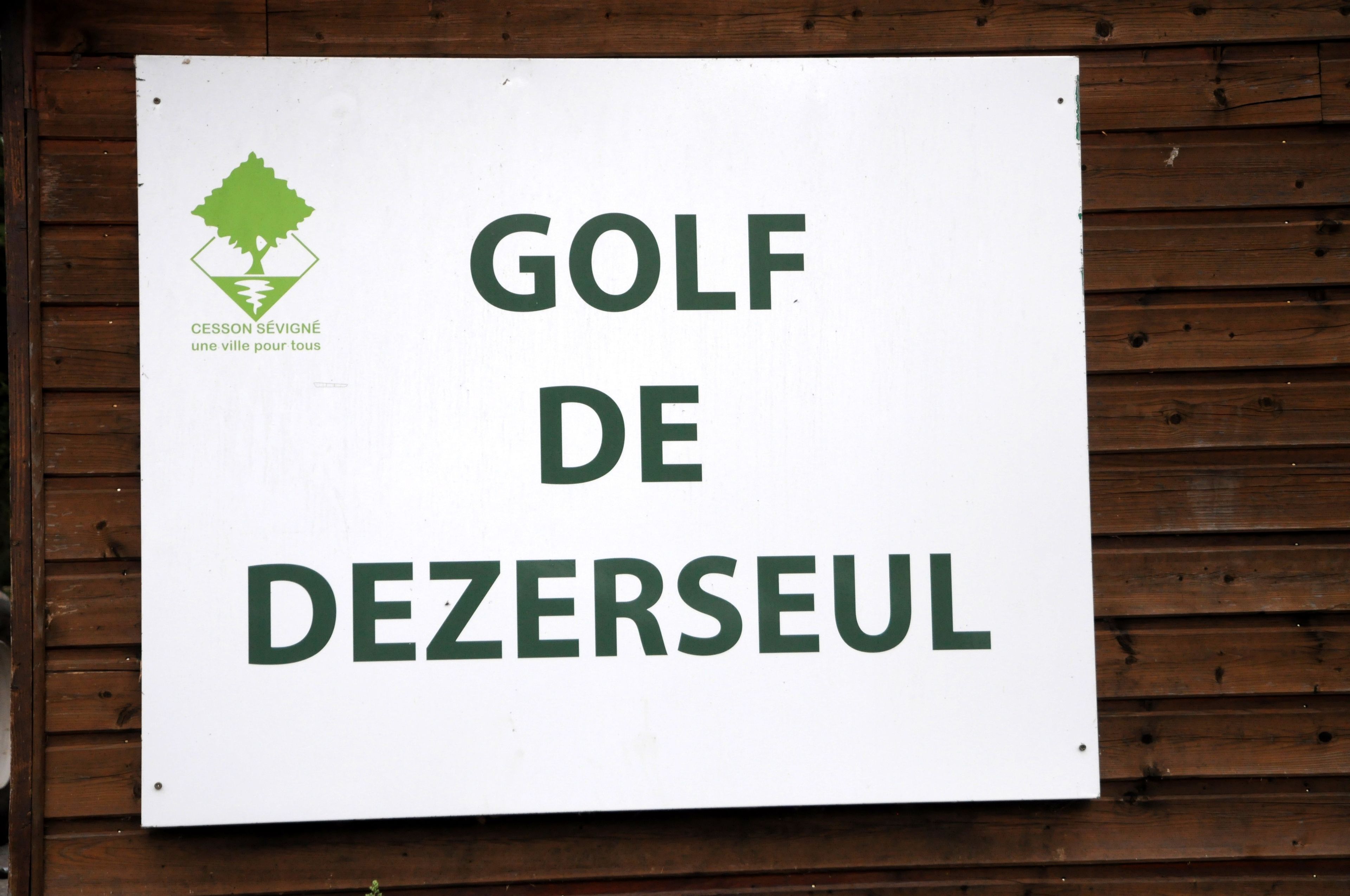 A sign for 'GOLF DE DEZERSEUL' with a logo of a tree and the text 'CESSON SEVIGNÉ une ville pour tous'.