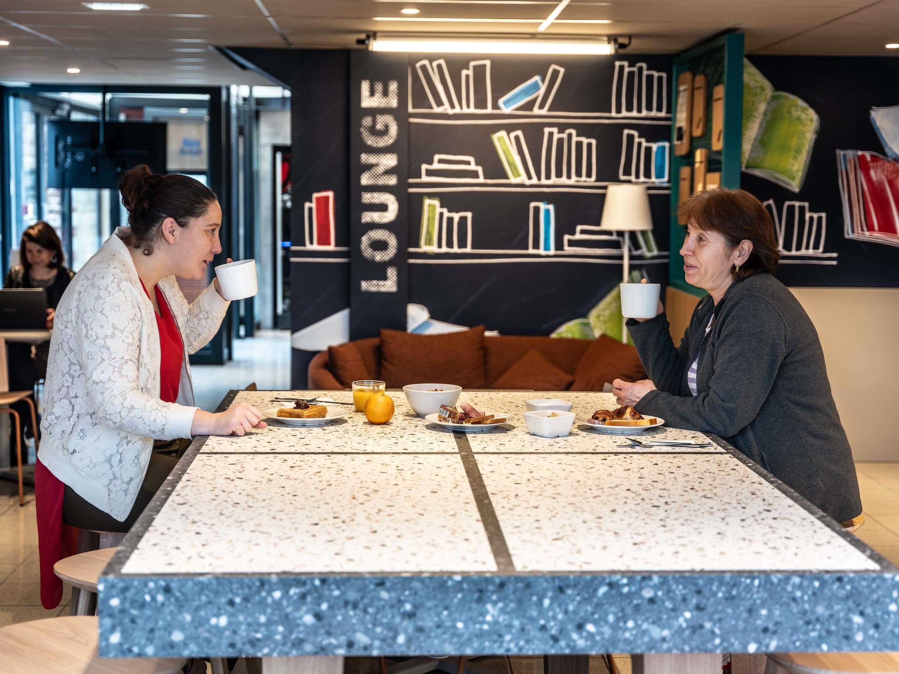 Un espace de détente moderne avec une grande table, des étagères et un canapé.