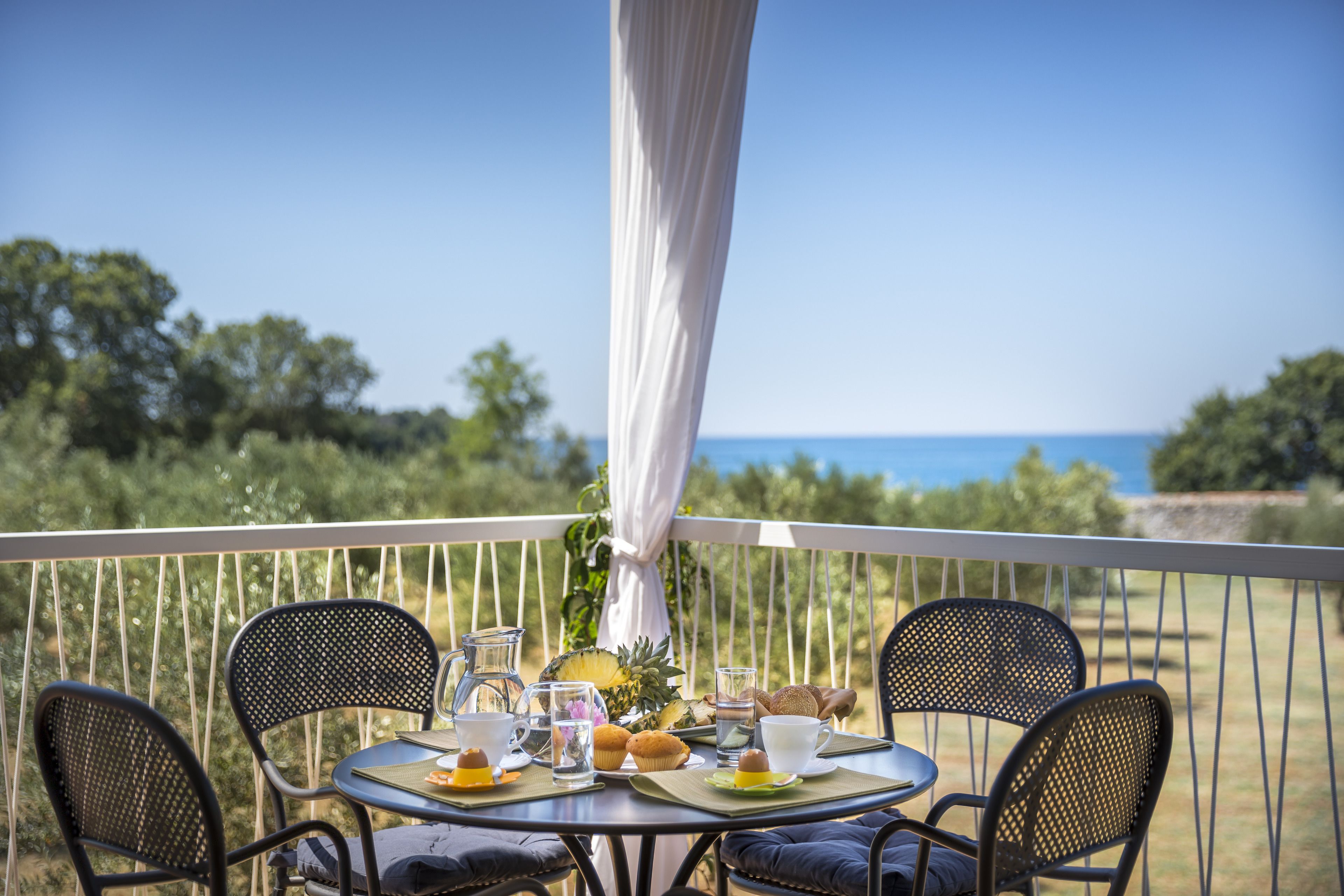 Un balcone con un tavolo apparecchiato per la colazione, vista panoramica.