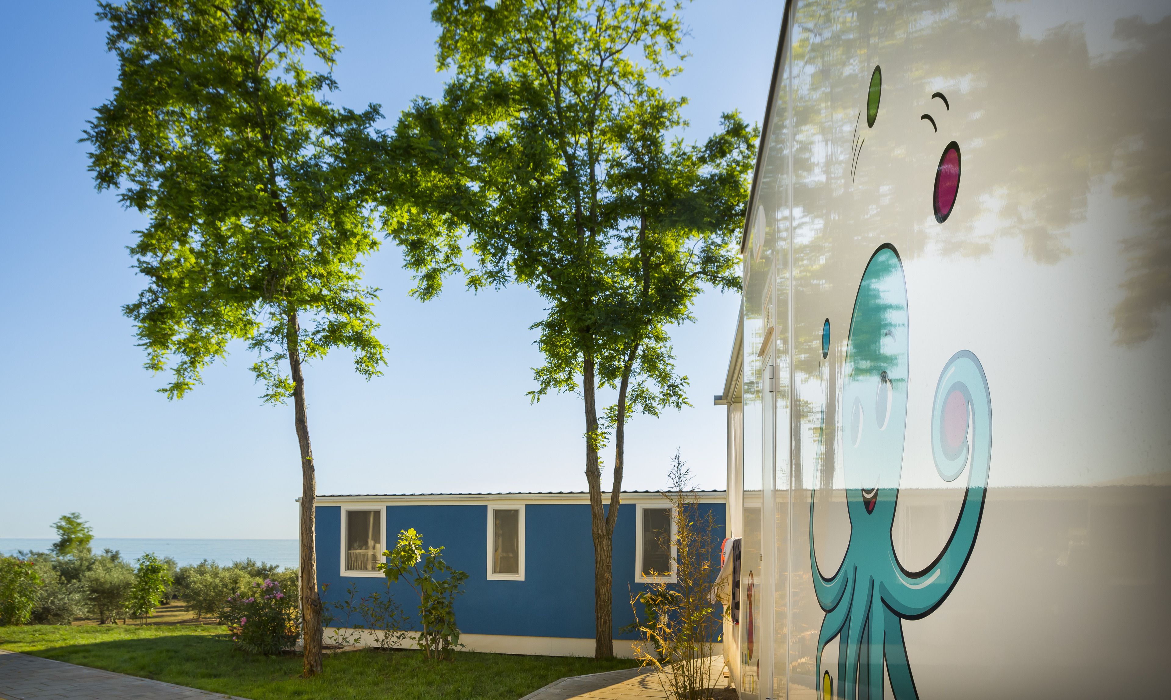 A building with a blue exterior and a large octopus mural.