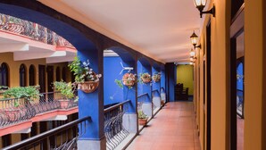 A corridor with tiled flooring, blue walls, and black railings. - Hotel Villa Española (Guatemala City)