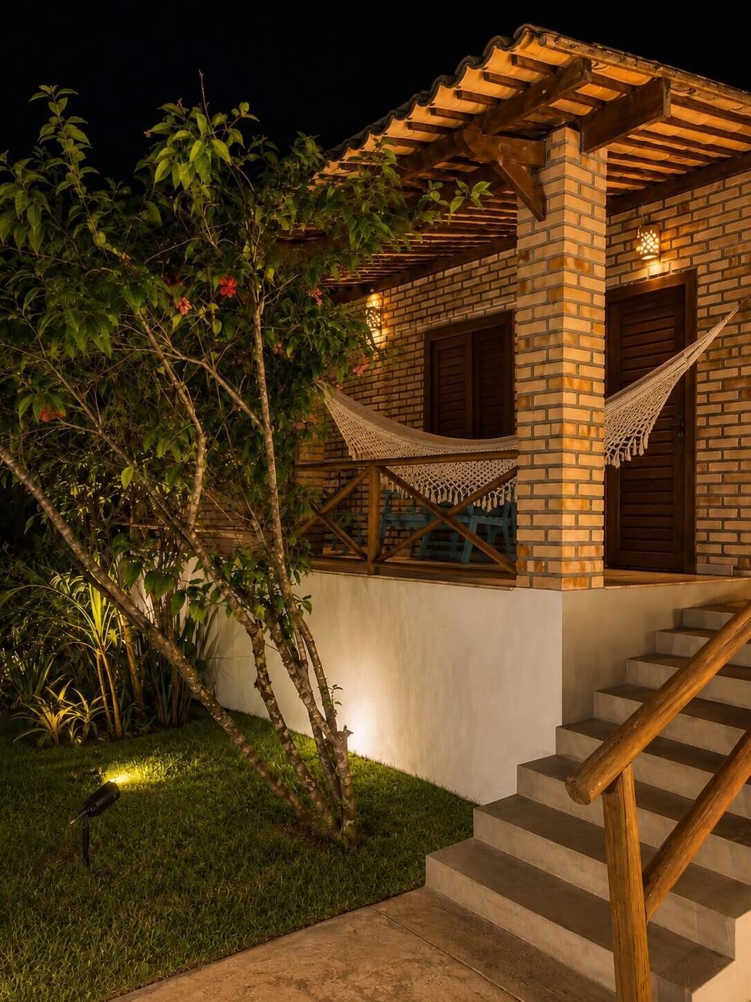 A brick building with a wooden staircase and a hammock.