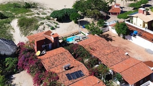 Eine Küstenlandschaft mit Sandstrand, blauem Himmel und Gebäuden mit roten Ziegeldächern.