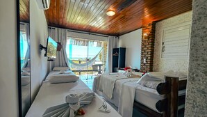 Ein Hotelzimmer mit zwei Betten, einer Hängematte, einem Fernseher und Blick ins Freie.
