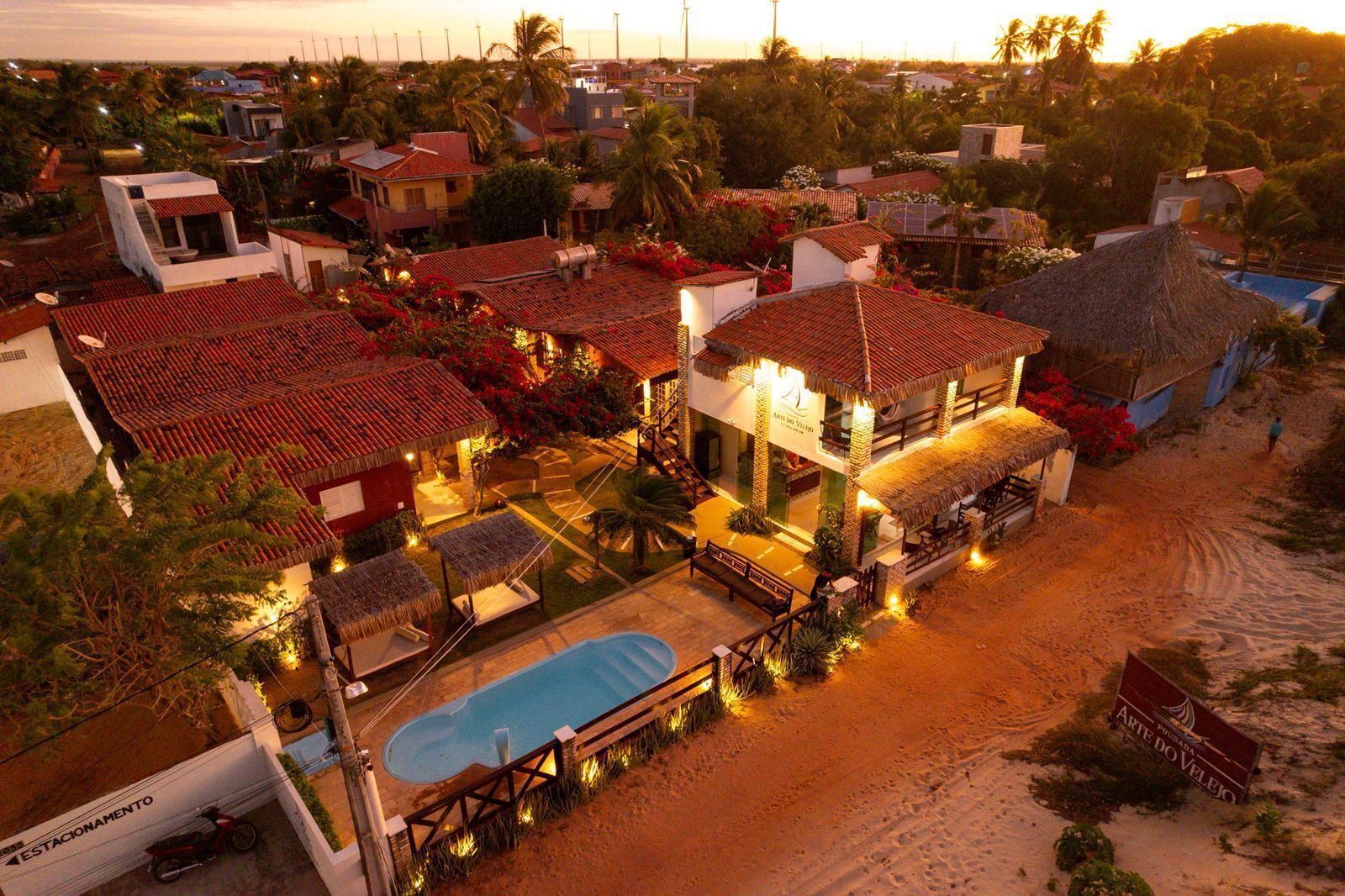 A resort with multiple buildings, a swimming pool, and a beach area.