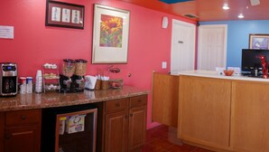 A kitchen with a microwave, coffee maker, and various kitchen appliances. There is a wooden counter and a sink. - Morning Star Inn (Anson)