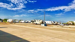 A row of RVs parked in a lot with a clear blue sky. - Morning Star Inn (Anson)