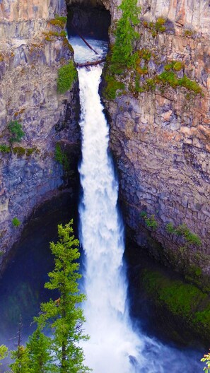A waterfall cascading down a rocky gorge with lush greenery at the base. - Hotel Civilia Lakeside by Civilia Golf Retreat (Clearwater)
