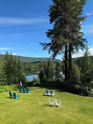 A grassy area with outdoor seating and a view of a lake and forest. - Hotel Civilia Lakeside by Civilia Golf Retreat (Clearwater)