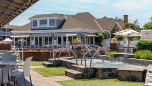 A pool area with a stone fountain, outdoor seating, and a covered patio. - Anchorage by the Sea (Ogunquit)