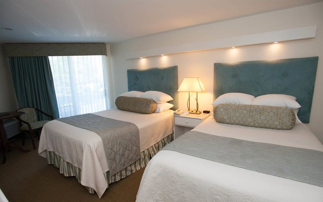Une chambre d’hôtel avec deux lits, un bureau et une chaise.
