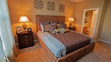 A bedroom with a wooden bed, two bedside tables with lamps, and decorative wall art.
