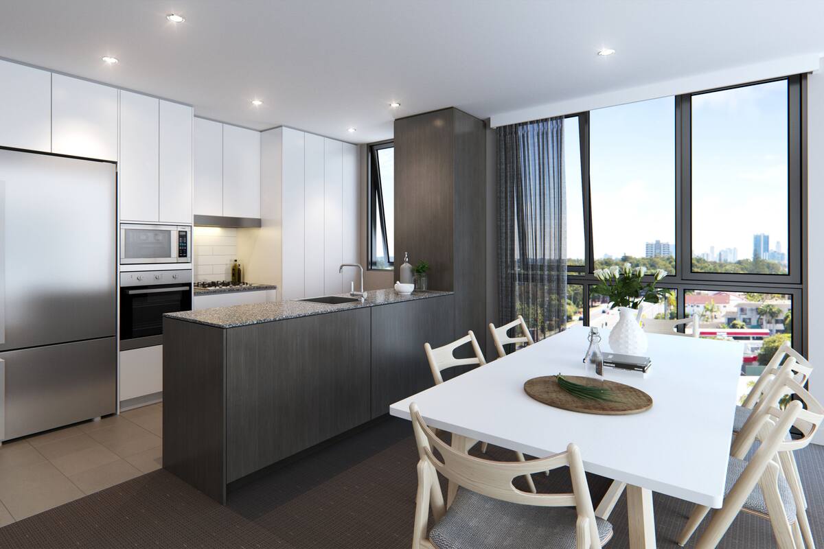 A modern kitchen with a central island, stainless steel appliances, and a dining area with a white table and chairs.