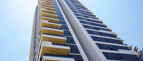 A tall, modern building with a series of balconies and windows.